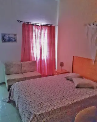a bedroom with a bed and a couch and a window at Mix 2 in Mindelo