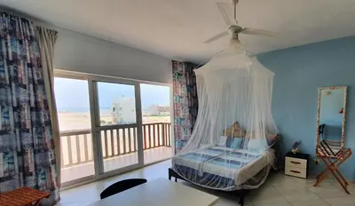 a bedroom with a canopy bed and a balcony at EMPFEHLUNG der MEERJUNGFRAU in Sal Rei