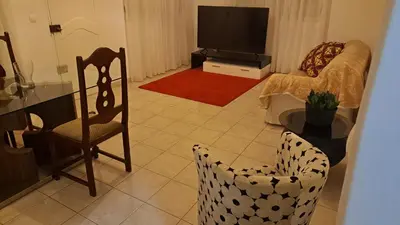 a living room with a tv and a chair at Casa Mendes in Tarrafal