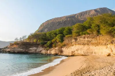 a sandy beach with a mountain in the background at Casa Mendes in Tarrafal