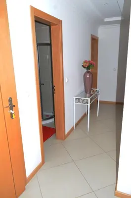 a hallway with a table and a vase on it at Apartamento Justino in Praia