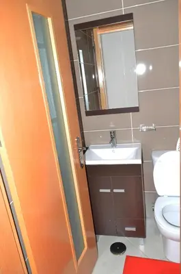 a bathroom with a sink and a toilet and a mirror at Apartamento Justino in Praia