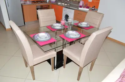 a dining room table and chairs with pink napkins at Apartamento Justino in Praia
