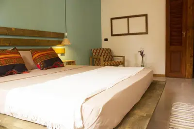 a bedroom with a large white bed and a chair at Casa Pau in Santa Maria