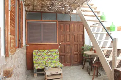 a wooden door with a chair next to a stairs at Casa Pau in Santa Maria