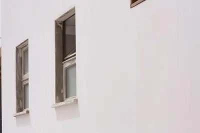 two windows on the side of a white building at Casa Pau in Santa Maria