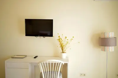 a white desk with a chair and a tv on a wall at Ouril Hotel Agueda in Sal Rei