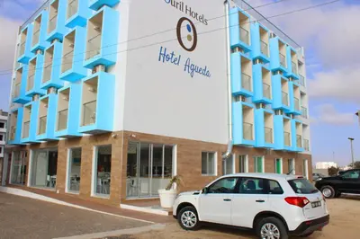 a white car parked in front of a building at Ouril Hotel Agueda in Sal Rei