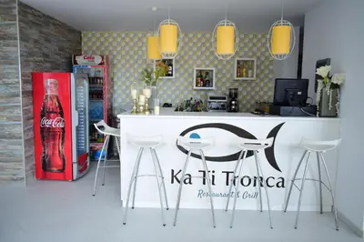 a kitchen with a bar with stools and a coke machine at Ouril Hotel Agueda in Sal Rei