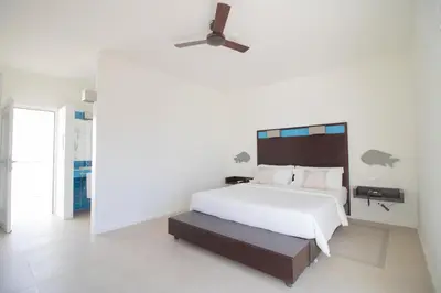 a bedroom with a white bed and a ceiling fan at Hotel Dunas de Sal in Santa Maria