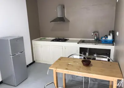 a kitchen with a table and a sink and a refrigerator at Salzen Portas de Sol in Santa Maria