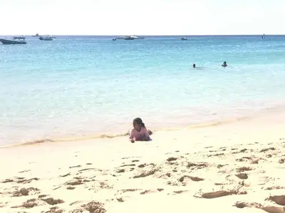 a little girl playing in the sand on the beach at Salzen Portas de Sol in Santa Maria