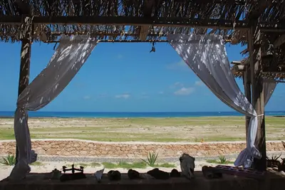 a view of the beach from the porch of a beach house at Spinguera Ecolodge in Espingueira