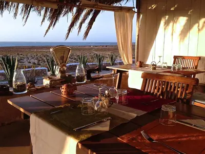a dining table with a view of the desert at Spinguera Ecolodge in Espingueira