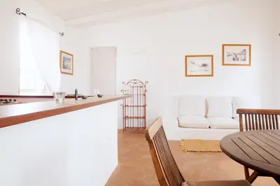 a kitchen and living room with a table and a couch at Spinguera Ecolodge in Espingueira