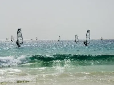 a group of people windsurfing in the ocean at Porto Antigo - Charming & peaceful apartment overlooking pool and sea in Santa Maria