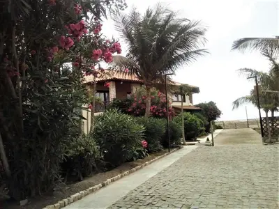 a house with a palm tree and a cobblestone street at Porto Antigo - Charming & peaceful apartment overlooking pool and sea in Santa Maria