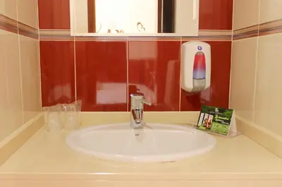 a bathroom sink with a soap dispenser next to it at Hotel LIVVO Don Paco in Mindelo