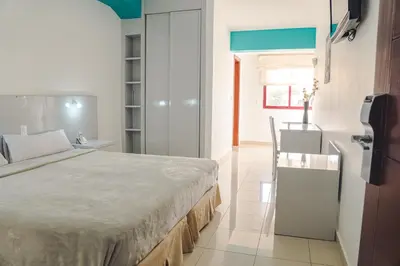 a bedroom with a large bed and a table at Hotel LIVVO Don Paco in Mindelo
