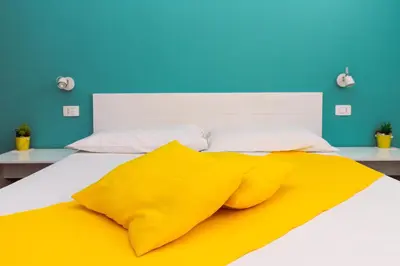 a bed with a yellow blanket on top of it at Apartamento Las Rochas in Mindelo