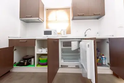 a kitchen with a sink and an open refrigerator at Apartamento Las Rochas in Mindelo