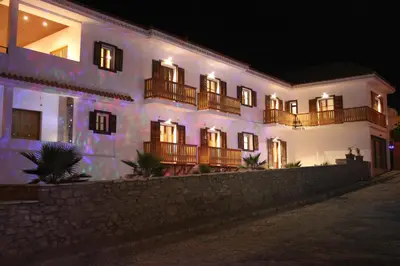a white building with balconies on a street at night at Hotel Casa Evora - luxury and beach front in Vila do Maio
