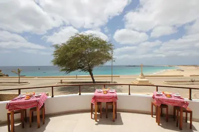 a balcony with two tables and a view of the beach at Hotel Casa Evora - luxury and beach front in Vila do Maio