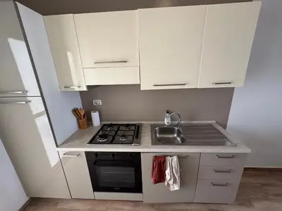 a small kitchen with white cabinets and a sink at CA MINHA Praia Estoril Sal Rei Boa Vista in Sal Rei