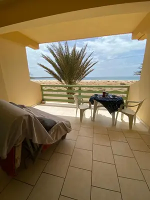 a bedroom with a view of the ocean and a table and chairs at Sea view Ka Paola, Praia Cabral, Boa Vista, FREE WI-FI in Sal Rei