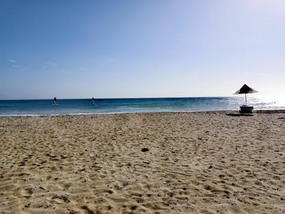 a beach with an umbrella and the ocean at Sal Service beachside angulo in Santa Maria