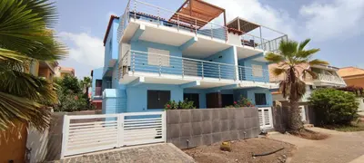 a blue and white house with a balcony at Sal Service beachside angulo in Santa Maria