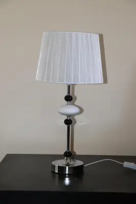 a lamp sitting on top of a table with a white lamp at Apartamento Preguiça in Espargos