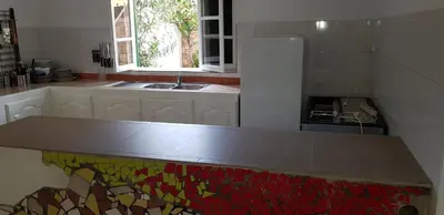 a kitchen with a counter with a sink and a window at Surf House Hostel in Santa Maria