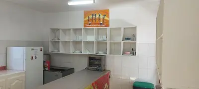 a kitchen with white cabinets and a refrigerator at Surf House Hostel in Santa Maria