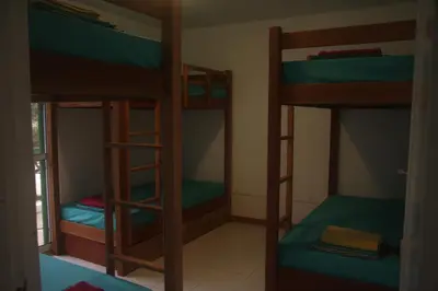 a room with three bunk beds in a room at Surf House Hostel in Santa Maria