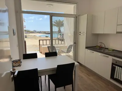 a kitchen with a table and a view of the beach at Casa Tud Dret - By Bobbywashere in Sal Rei