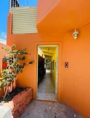 an orange building with a hallway leading to a door at La Residencia in Mindelo