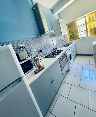 a kitchen with white counters and a stove top oven at La Residencia in Mindelo