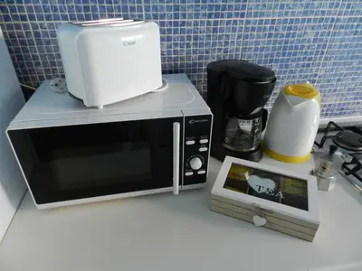 a microwave sitting on top of a counter with a toaster at La Residencia in Mindelo