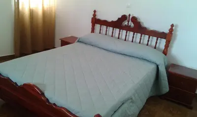 a bedroom with a bed with a wooden headboard at Casa Amarela in Ponta do Sol