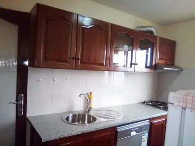 a kitchen with a sink and wooden cabinets at Casa Amarela in Ponta do Sol