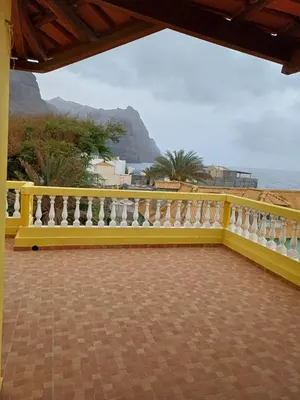 a yellow fence with a view of the ocean at Casa Amarela in Ponta do Sol