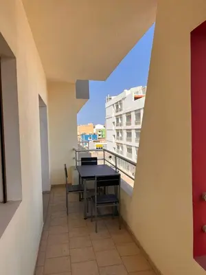 a balcony with a table and chairs and a building at SGC Boa Vista Apartments in Sal Rei