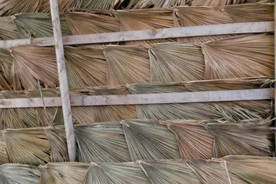 a stack of straw hats on a wooden shelf at Pensão Alcinda Bettencourt 50 meters to the Beachfront in Santa Maria