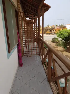a balcony of a house with a wooden railing at Pensão Alcinda Bettencourt 50 meters to the Beachfront in Santa Maria