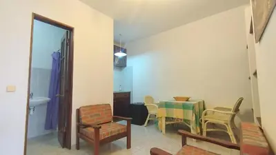 a living room with a table and chairs at Pensão Alcinda Bettencourt 50 meters to the Beachfront in Santa Maria