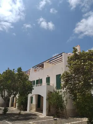 a white building with trees in front of it at Guesthouse Le Châtelain in Santa Maria