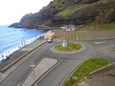 a winding road next to the ocean next to a mountain at Guest House Frontera in Pinto