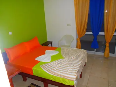 a bedroom with a bed with orange and green at Guest House Frontera in Pinto