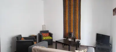 a living room with two chairs and a tv at Casa Verde in Mindelo